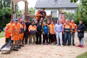  Gemeinsam bei der Spielplatz-Einweihung (von rechts): Bezirksbürgermeister Frederik Suchla, Gärtnermeister Dietrich Kopp (UWB), Abteilungsleiter Sebastian Richter (UWB), Dirk Althoff (UWB) sowie Gärtner des UWB und die elf freiwilligen Helferinnen und Helfer.  